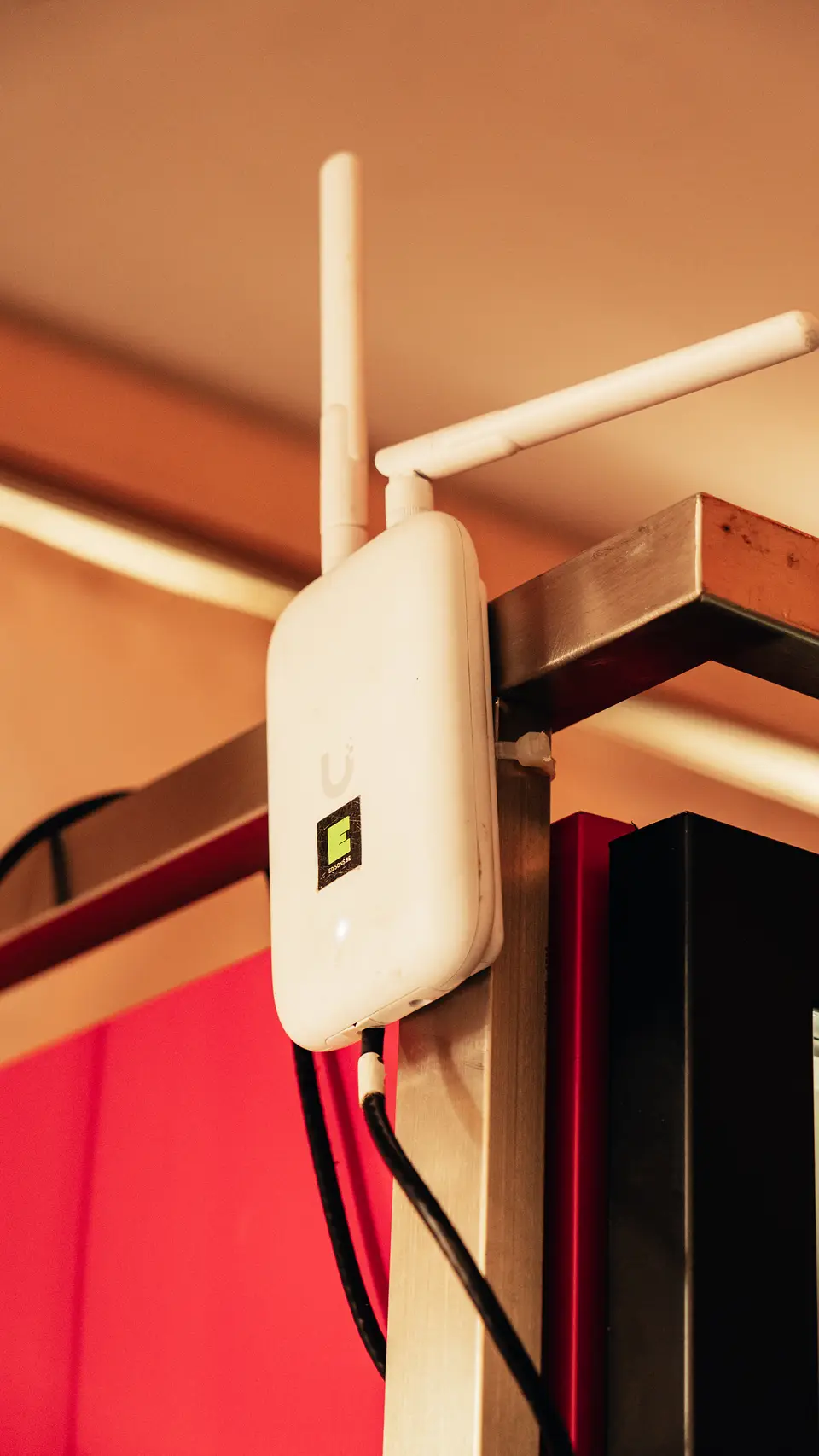Wifi accesspoint met buitenantenne aan een bar op een evenement, aangesloten op het tijdelijke netwerk