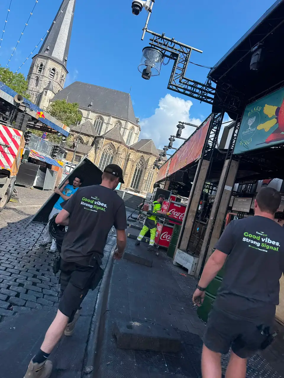 Technicus van EventWiFi legt bekabeling over een plein tijdens de opbouw van de Gentse Feesten