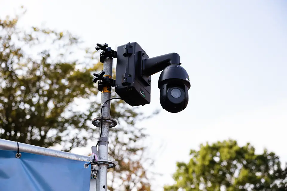 Bestuurbare PTZ camera van EventWiFi op een mast aan de bosrand van het terrein van Rijvers Festival