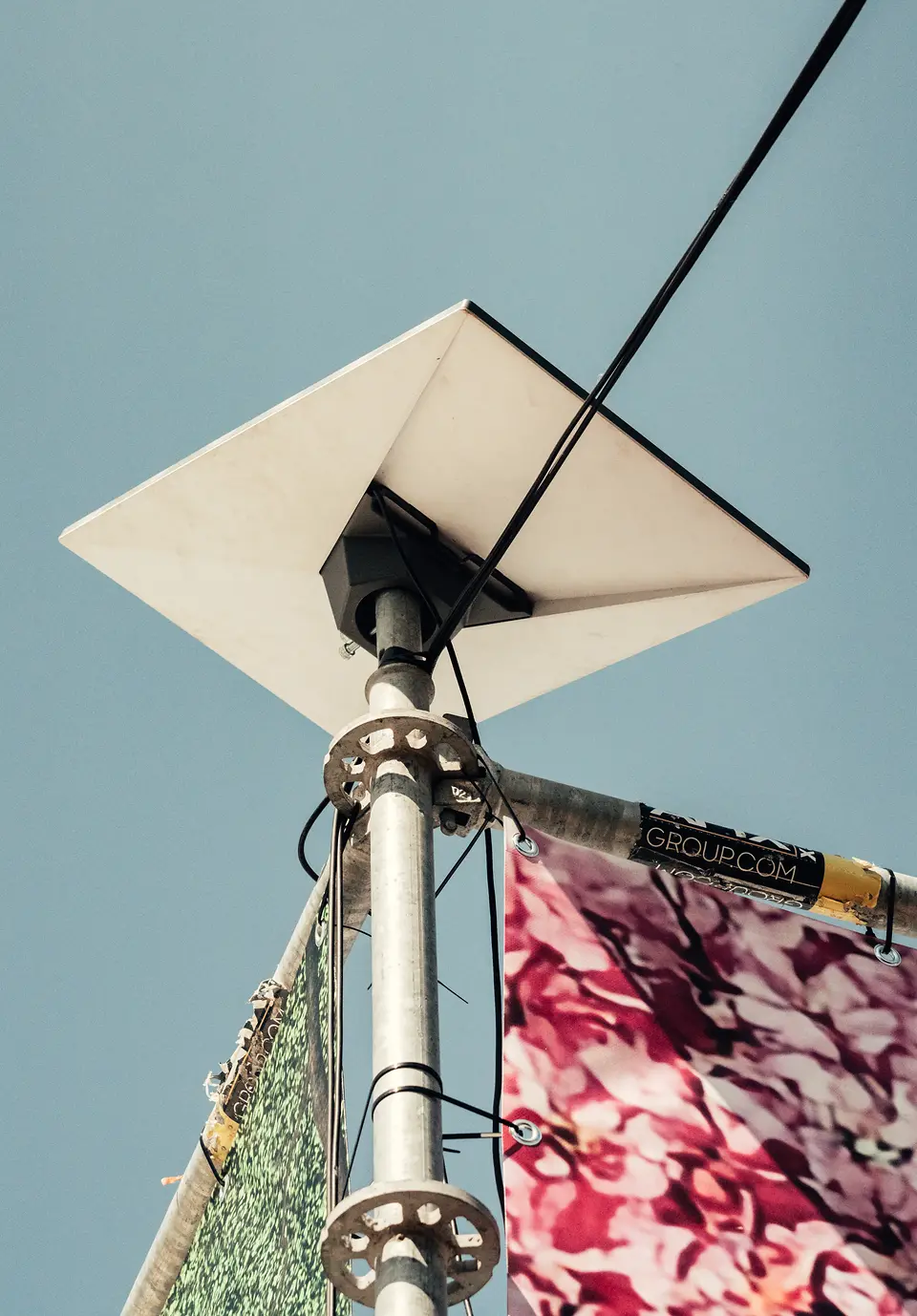 Starlink schotel op een mast boven een evenemententerrein tegen een blauwe lucht