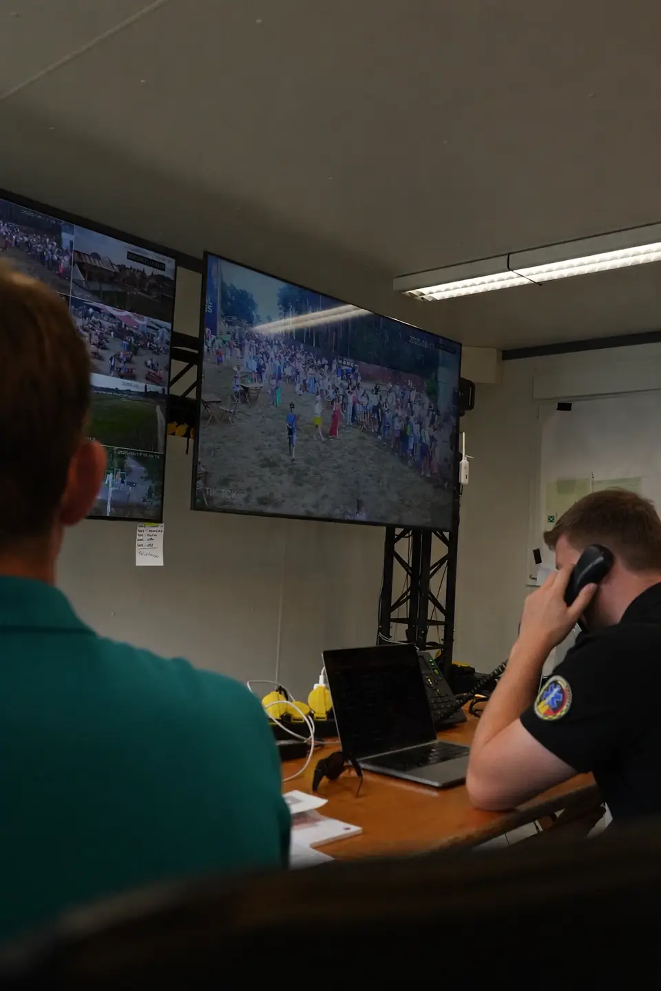 Crewlid belt via VOIP telefonie vanuit de controlekamer terwijl camerabeelden worden opgevolgd