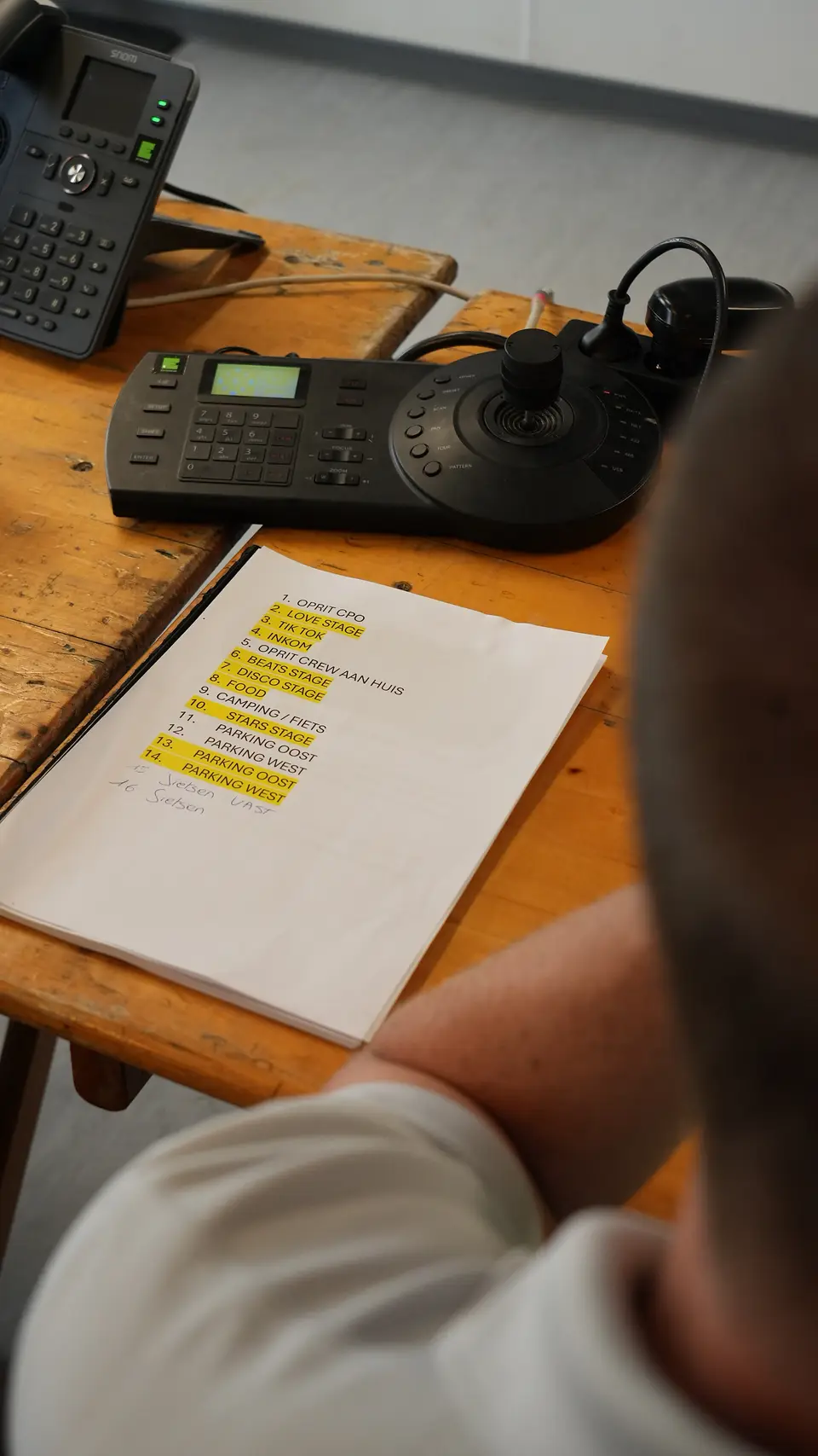 Vast VOIP toestel op een productiebureau naast draaiboeken tijdens een evenement